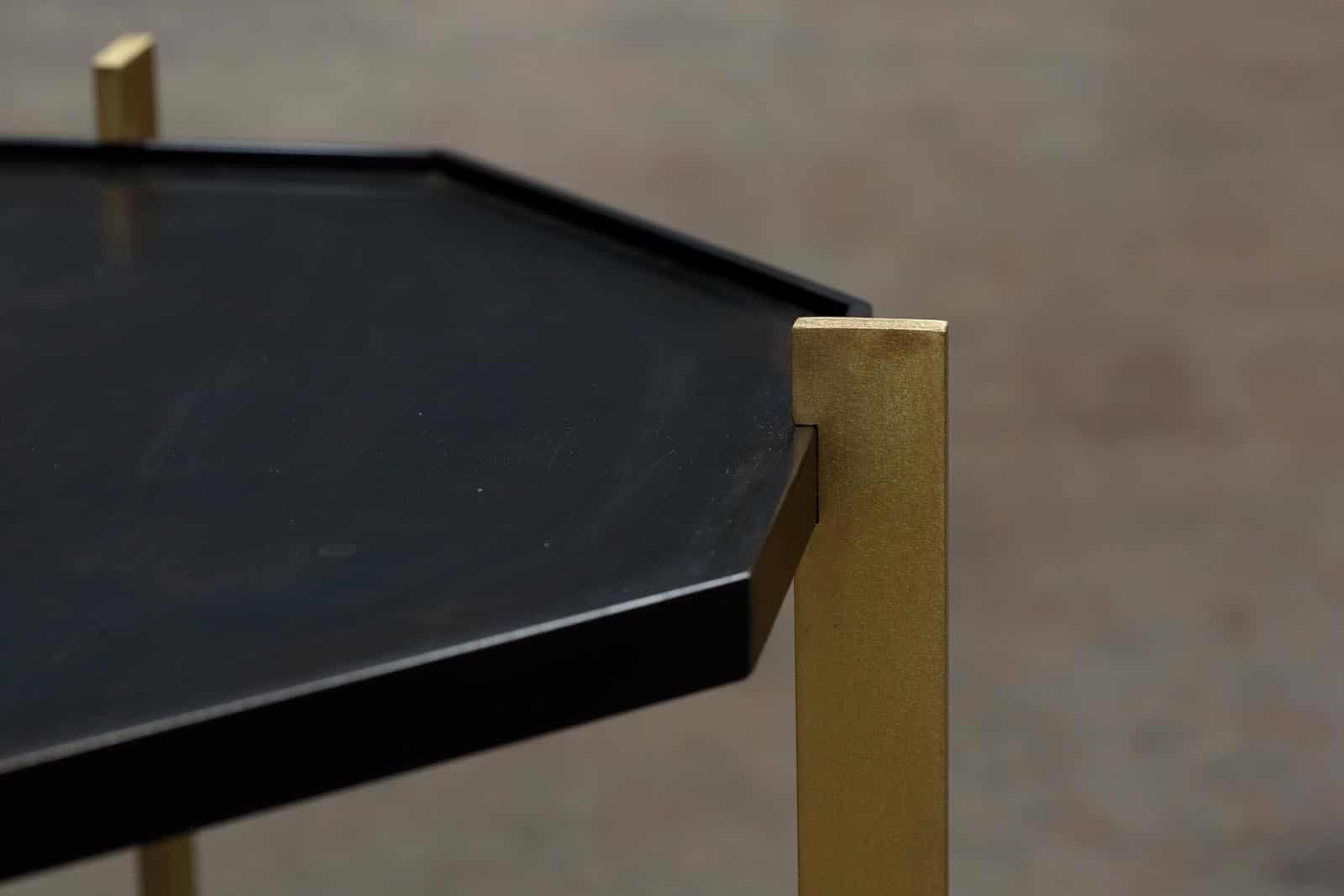 Close up of metallic octagon end table with gold metallic finished legs.